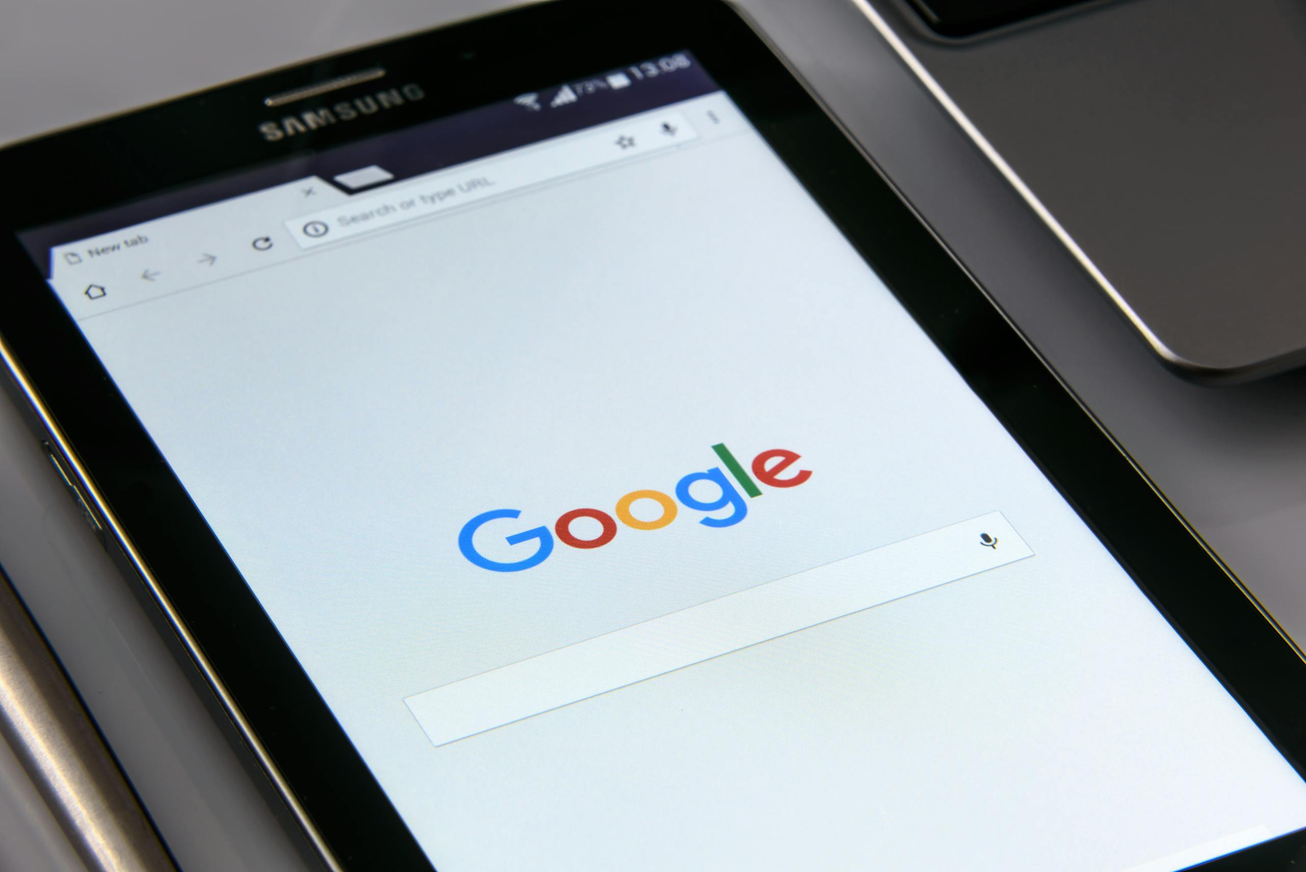 Close-up of a tablet displaying Google's search screen, emphasizing technology and internet browsing.